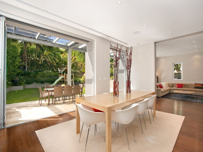 Modern dining room idea with floorboards & floor-to-ceiling windows ...